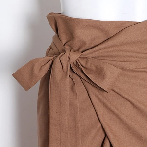 Détail du pantalon cargo à taille haute avec un grand nœud et une texture de tissu