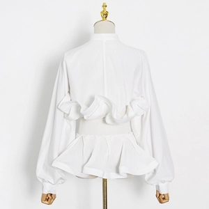 Detail of white lantern sleeves and wavy ruffle back pleats on a standing shirt
