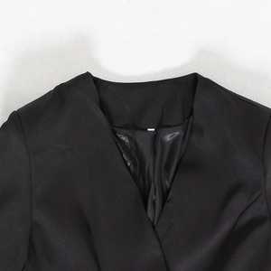 Detailed view of the V-neckline and premium satin fabric texture on this black blazer