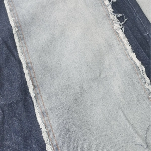 Macro detail of high-waist denim with contrast patchwork and orange contrast stitching