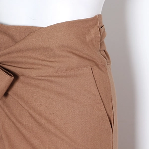 Détail du pantalon marron à taille haute avec ceinture à nouer et texture de coton-lin