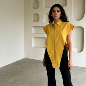Detailed view of ginger yellow asymmetrical lapel shirt with pointed irregular hemline