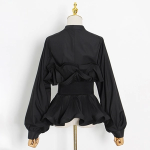Detail of black stand-collar blouse featuring pleated ruffles and tiered lantern sleeves