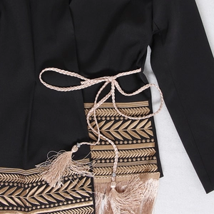 Detail of gold leaf embroidery and champagne woven belt with tassels on black blazer