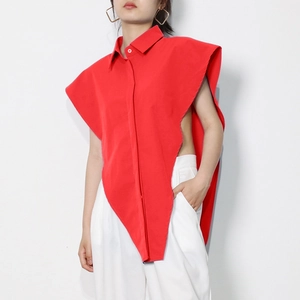Detail of red irregular vest top featuring asymmetrical cut and sharp triangular hemline