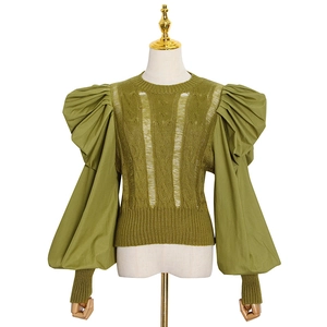 Detail of olive green knit top featuring distressed textures and puff woven sleeves