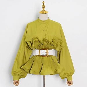 Detail of mustard yellow ruffled shirt featuring pleated lantern sleeves and a white belt