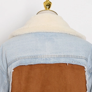 Detail of light blue denim jacket with faux shearling collar and distressed raw edges