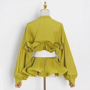 Back view of mustard green blouse with layered ruffles and lantern sleeves on mannequin