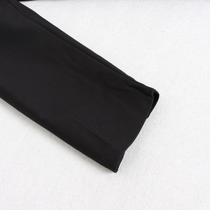 Detailed close-up of the black suit cuff showing fine stitching and matte fabric texture