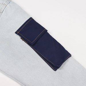 Detailed close-up of light blue denim fabric with a navy cargo pocket and orange stitching