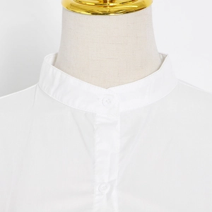 Detail of white shirt band collar with a single button and pleated fabric texture