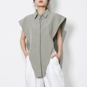 Detail of grey-green sleeveless shirt featuring a sharp asymmetric pointed hem design