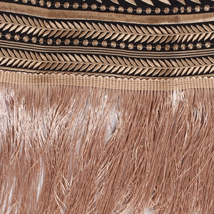 Detailed close-up of intricate gold embroidery and elegant long fringe on a black blazer