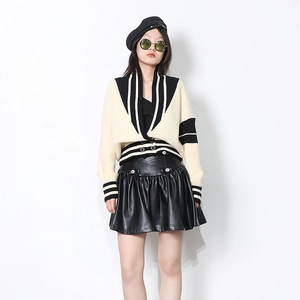 Gros plan du cardigan en maille crème avec bordure noire, col en V et boutons noirs