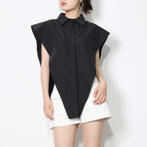Detail of the unique inverted triangular asymmetric hem on this black sleeveless shirt