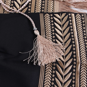 Macro shot of gold embroidery textures and tassels on a black wrap blazer jacket