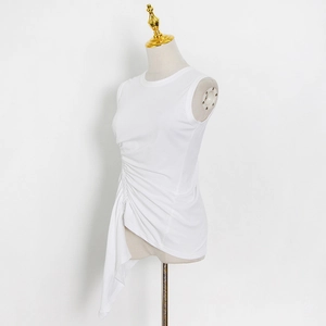 Detailed view of ruched waist design on a white sleeveless top with asymmetric hem