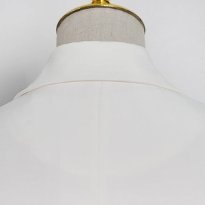 Close-up of white blazer back collar showing clean tailoring and center seam stitching