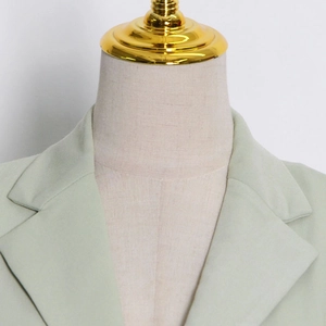 Detailed view of light green blazer featuring classic notched lapels and neat shoulder stitching