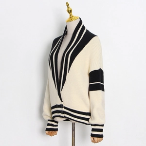 Détail du cardigan en maille crème avec rayures noires et texture épaisse en relief