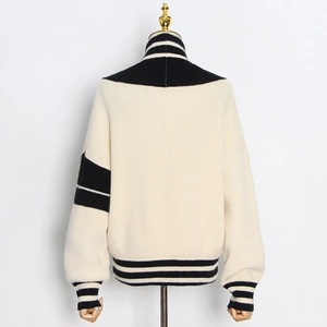 Détails du pull en maille crème avec rayures contrastées sur le col et l'ourlet