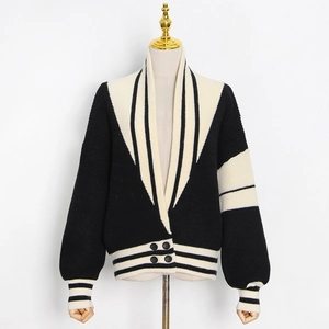Détail du cardigan en maille à col en V avec rayures noires et blanches et boutons