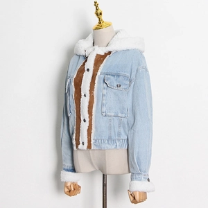 Dettaglio della giacca di jeans blu con bordo in agnello bianco e patchwork in pelle scamosciata