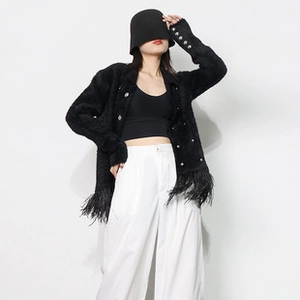 Close-up of black fuzzy cardigan featuring silver buttons and elegant feather hem detail