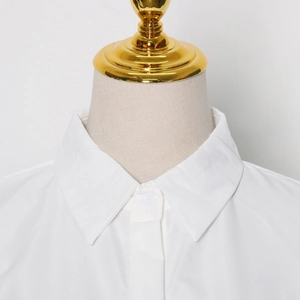 Close-up of white lapel collar and button detail on a sleeveless casual cotton shirt