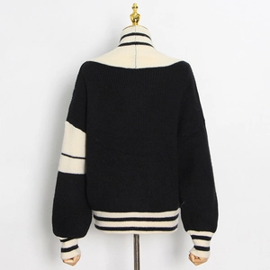 Détail d'un pull rayé noir et blanc montrant les poignets côtelés et la texture