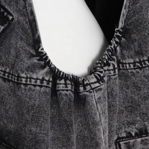 Détail du tissu denim délavé montrant la taille élastique et les coutures à double aiguille