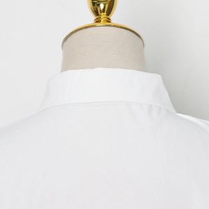 Detailed close-up of white sleeveless shirt collar and shoulder cut on a mannequin
