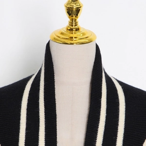 Détail du col en V sur cardigan en maille noire avec rayures blanches contrastées
