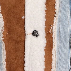 Dettaglio della giacca in denim con bordo in lana d'agnello e bottone in metallo