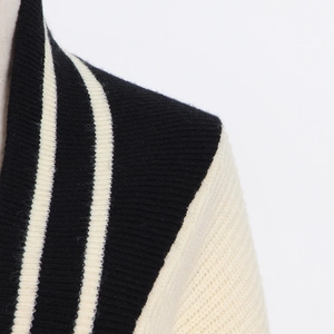 Vue détaillée de la maille côtelée et du motif à rayures sur l'épaule du cardigan noir