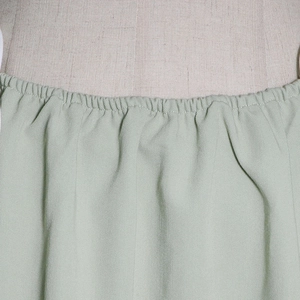 Detailed macro view of the light mint green elastic waistband and twill fabric texture