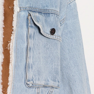 Dettaglio della giacca di jeans con fodera in shearling e bottone in metallo inciso Jeans
