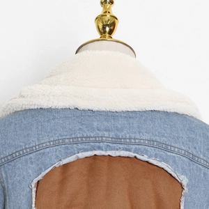Dettaglio giacca denim patchwork con colletto in lana d'agnello e pannello in pelle scamosciata