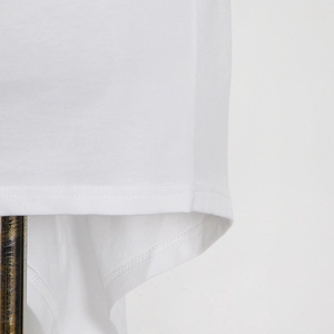 Detailed close-up of double-needle stitching on the hem of a white cotton knit T-shirt