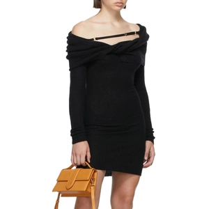 Detail of off-shoulder black knit dress with decorative straps and ribbed texture
