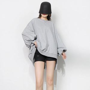 Detail of oversized gray crewneck sweatshirt with lantern sleeves and asymmetric hem