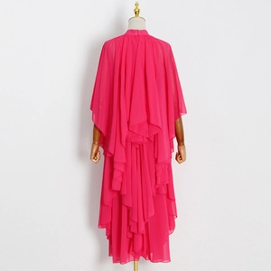Vue détaillée de la robe en mousseline magenta à volants avec manches cape et ourlet fluide