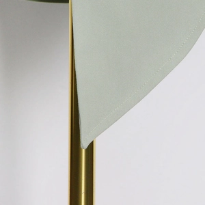 Detailed close-up of golden metal support rod and mint green fabric with neat stitching