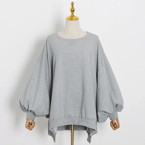 Detail view of grey oversized crewneck sweatshirt with lantern sleeves and side slits