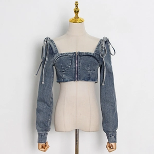 Detailed view of deep blue denim crop top with corset stitching and metal front zipper
