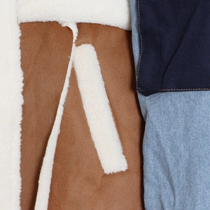 Dettaglio ravvicinato del patchwork di denim e della fodera in pelliccia sintetica bianca