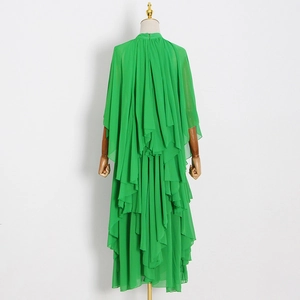 Détail de la robe en mousseline verte avec design cape multicouche et plis dans le dos