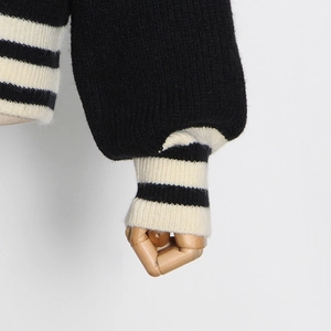 Détail du cardigan noir avec poignets rayés en maille côtelée et texture de laine premium