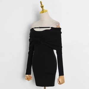 Detail of black knit dress showing off-shoulder neckline and twisted knot design texture